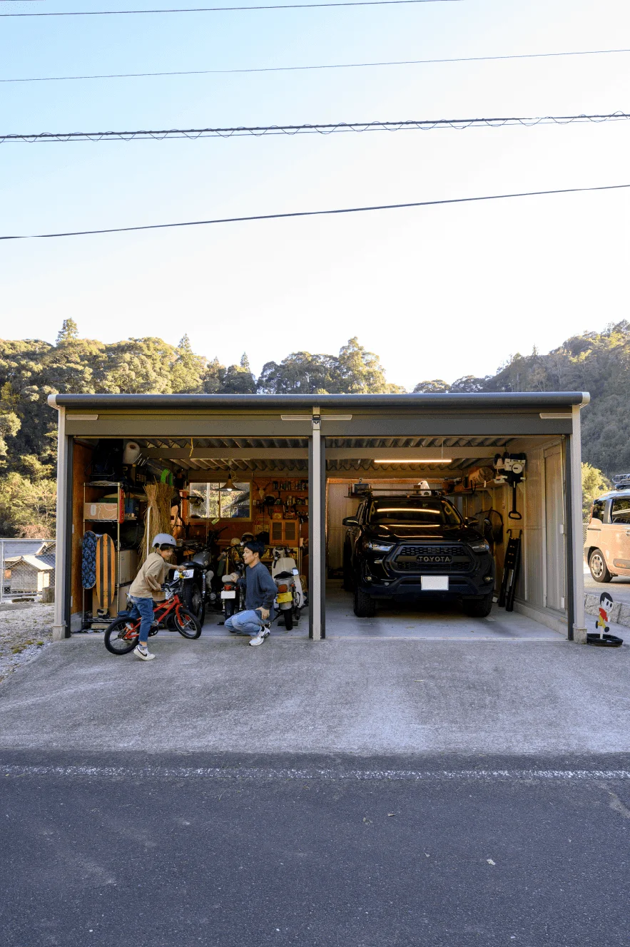 車やバイクが並ぶ大きなガレージの外観